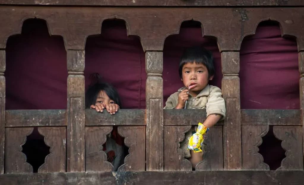 Kids looking out from window in Bhutan