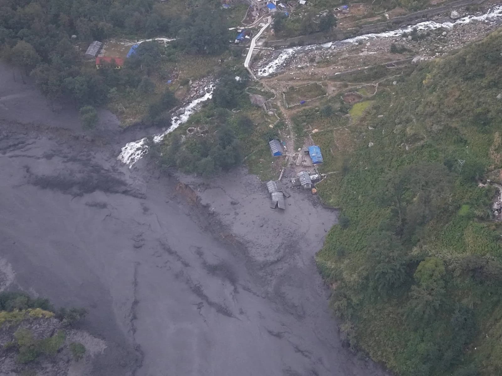 Aerial view of grey flood mud burying fields and houses in Gorkha after the Budhi Gandaki flood of 11 October 2026