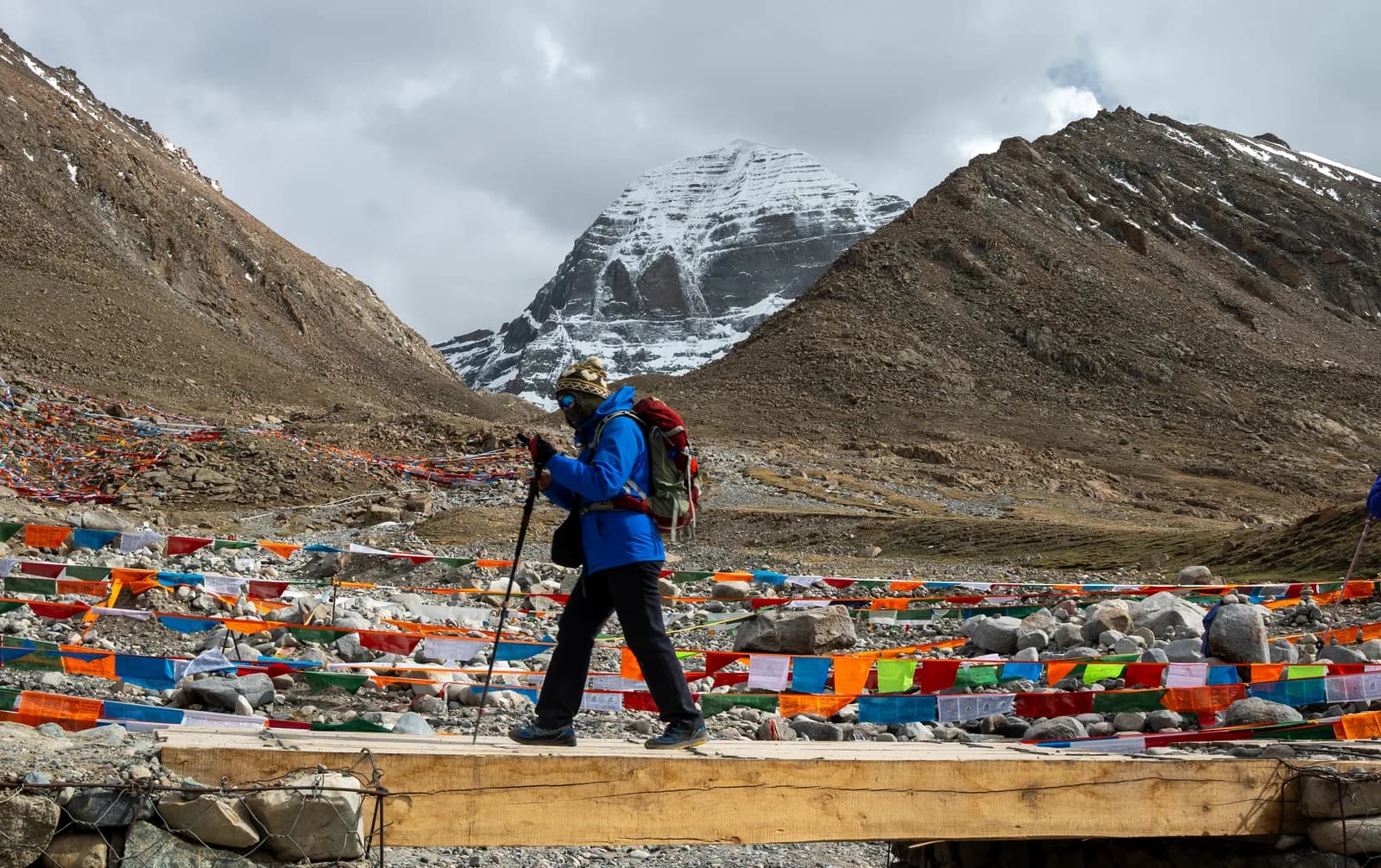 Pilgrim crossing a wooden bridge below Mount Kailash on the Kora