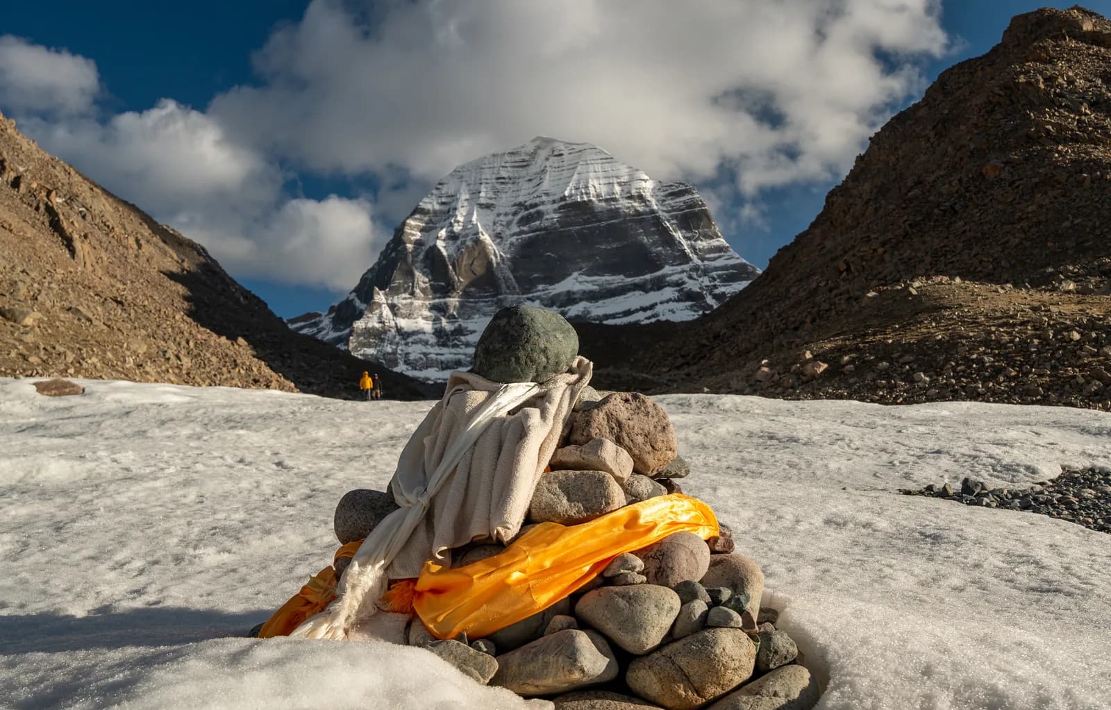 Stone cairn wrapped in khata scarves facing Mount Kailash's north face