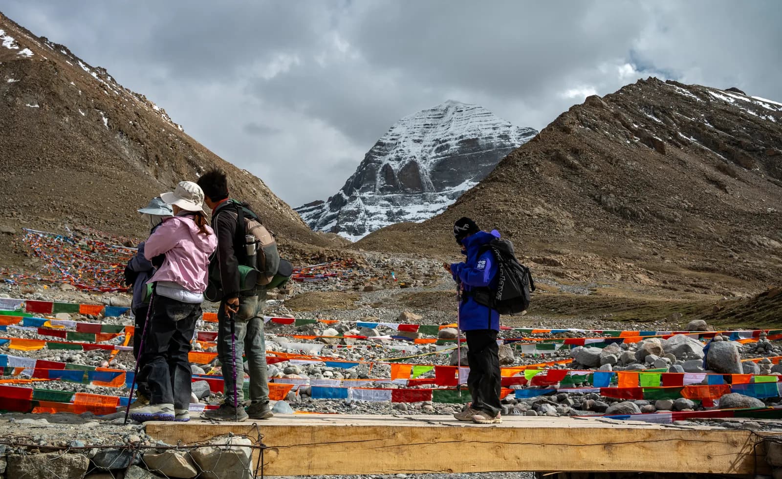 Pilgrims stopping on a Kora bridge to look at Mount Kailash