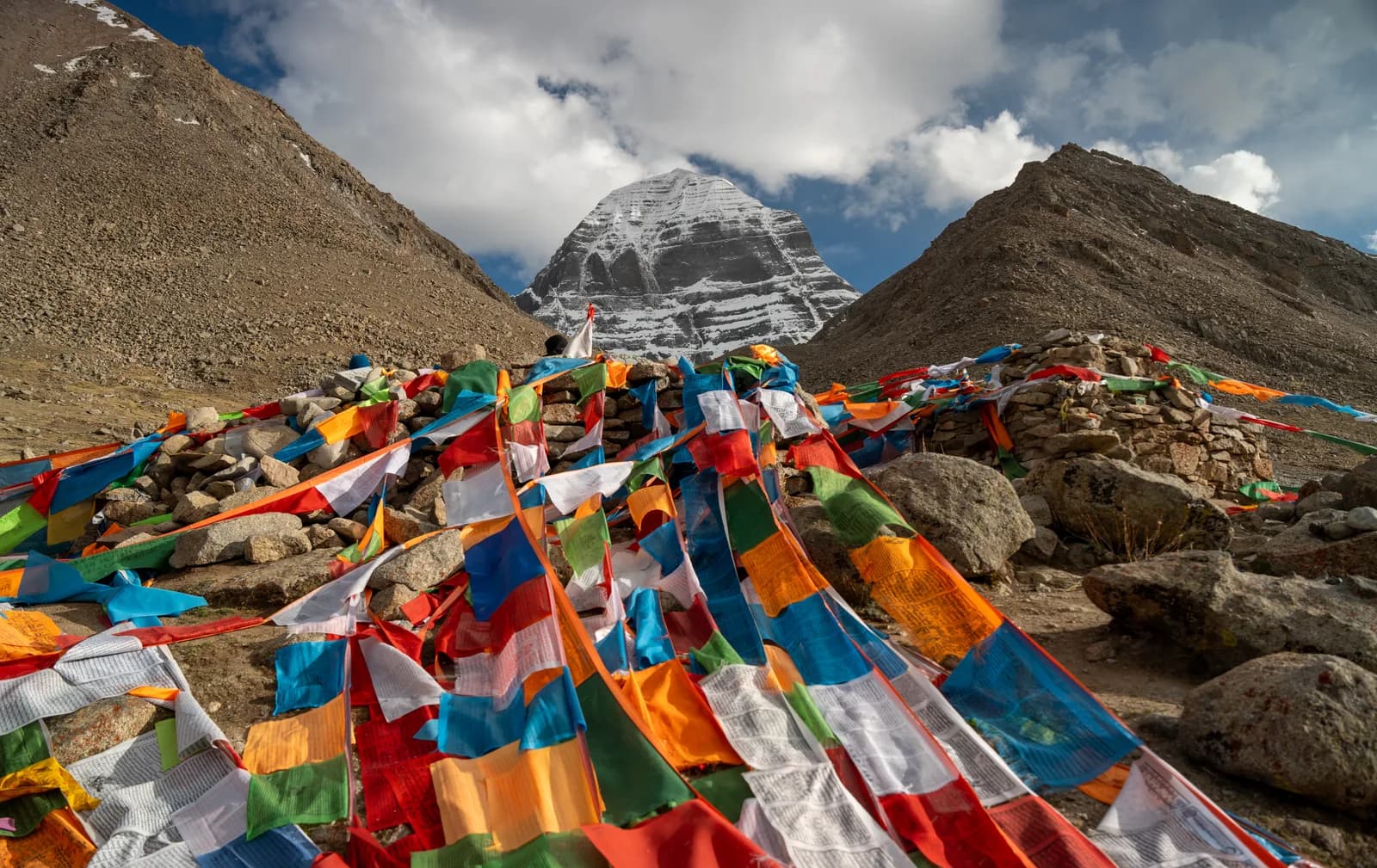 Prayer flags draped over rocks below the north face of Mount Kailash
