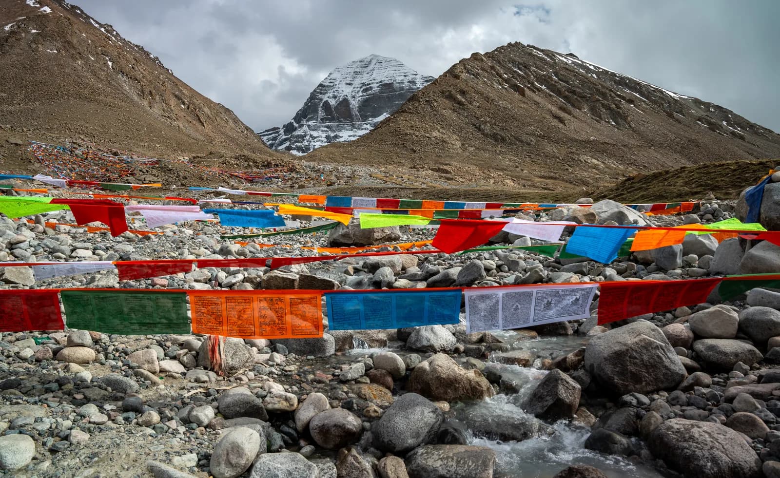 Prayer flags strung over a stream below Mount Kailash on the Kora
