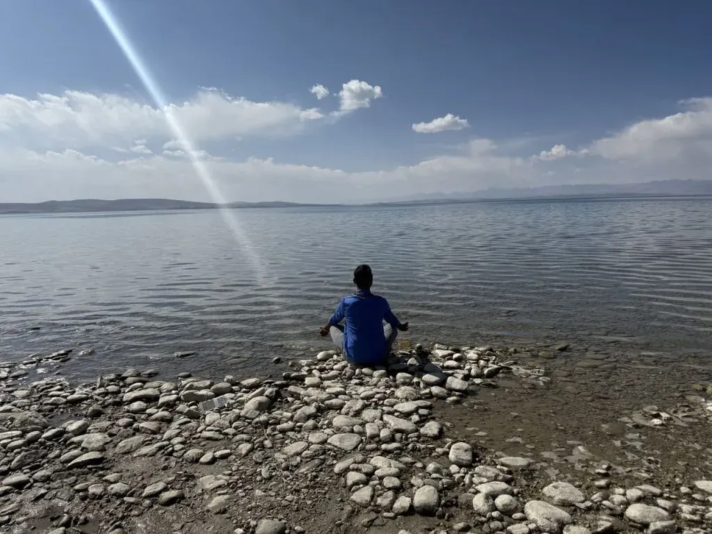person meditating on mansarovar lakeshore