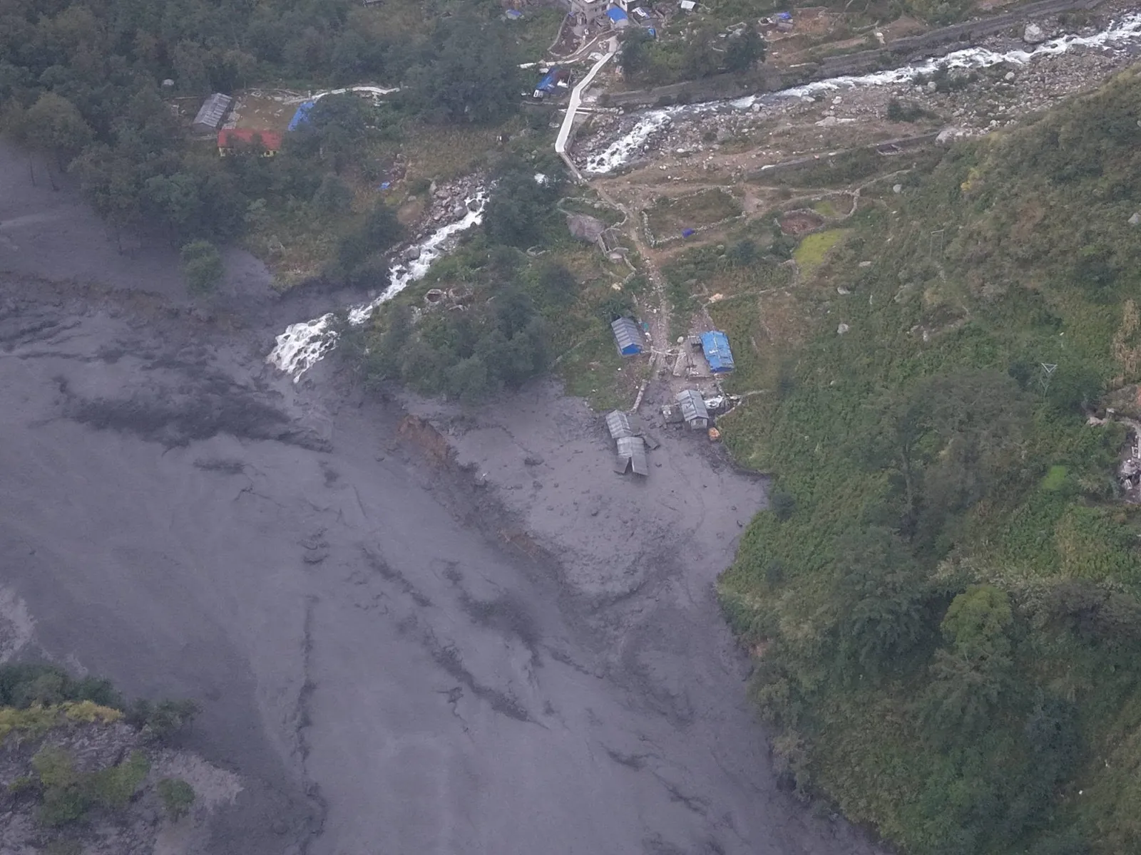 Aerial view of grey flood mud burying fields and houses in Gorkha after the Budhi Gandaki flood of 11 October 2026